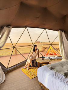a woman sitting at a table in a tent at X5 wadi Rum Luxury in Wadi Rum