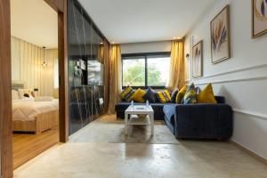 a living room with a blue couch and a bed at Le Nid Doré in Maarif