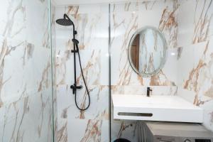 a bathroom with a shower and a sink and a mirror at Le Nid Doré in Maarif +12 photos