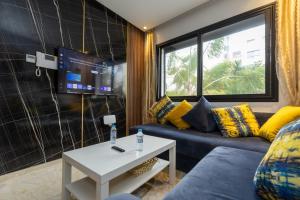 a living room with a couch and a tv at Le Nid Doré in Maarif