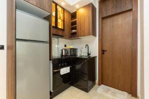 a kitchen with a white refrigerator and wooden cabinets at Le Nid Doré in Maarif