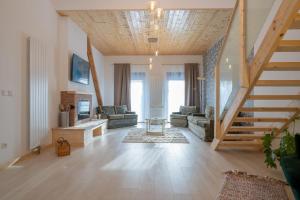 a large living room with a staircase and a living room with a couch at Hof Friesenruhe – Loft in Högel