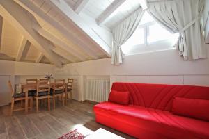 a living room with a red couch and a table at Villa Giuliana - Attic apartment in Menaggio