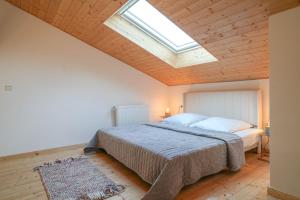 a bedroom with a large bed with a skylight at Hof Friesenruhe – Loft in Högel