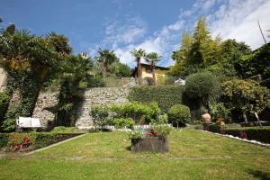 a garden with flowers and a stone wall at Villa Giuliana - Attic apartment in Menaggio