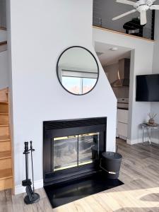 a living room with a fireplace and a mirror at La Première vue in Magog-Orford