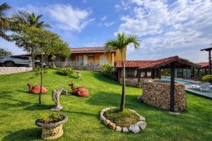 a house with some fake animals in the yard at Pousada Tanto Mar in Arraial do Cabo