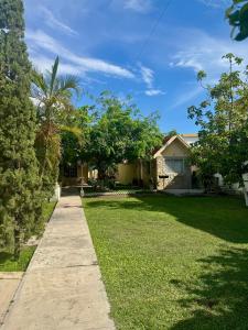 a house with a lawn and a sidewalk at Finca Nona's, Naturaleza y playa in Ciudad Madero