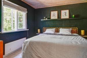 a bedroom with a bed and two windows at Peaceful Getaway in Åsljunga