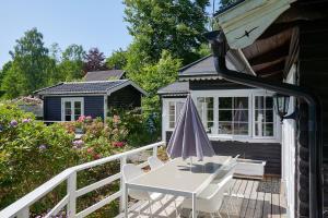 a patio with a white table and chairs and a house at Peaceful Getaway in Åsljunga