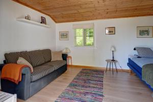 a living room with a couch and a bed at Peaceful Getaway in Åsljunga +15 photos