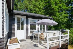 a deck with an umbrella and a table and chairs at Peaceful Getaway in Åsljunga
