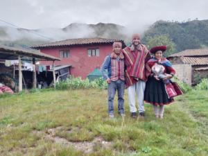 a group of people standing in a field in front of a house at Hospedaje Q'ello Qantu in Coper