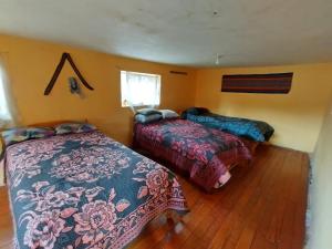 a bedroom with two beds and a window at Hospedaje Q'ello Qantu in Coper