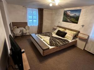 a bedroom with a bed and a table in it at Taverna Unik in Saaldorf +24 photos