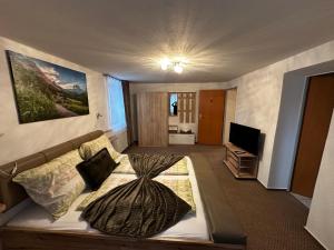 a living room with a bed and a television at Taverna Unik in Saaldorf