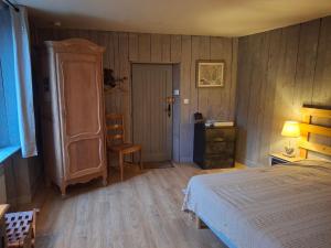 a bedroom with a bed and a dresser and a chair at La Grange Aux Mille Feuilles in Castres