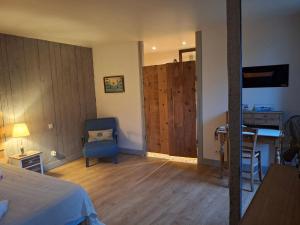 a bedroom with a bed and a table and a chair at La Grange Aux Mille Feuilles in Castres