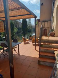 a patio with a table and a bench and stairs at La Grange Aux Mille Feuilles in Castres