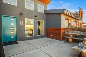 a home with a blue door and a patio at Timber & Tin H 2Bed 2Bath w Pool & Rooftop Deck in Kanab