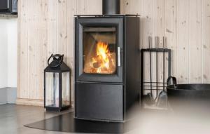 a stove with a fire in it in a room at Beach Front Home In Bogense With Sauna in Bogense