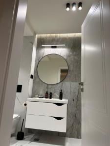 a bathroom with a white sink and a mirror at Deluxe Aparthotel Central2 in Zalău