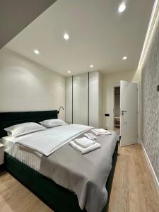 a bedroom with a large bed with white sheets at Deluxe Aparthotel Central2 in Zalău