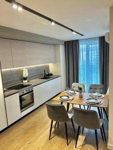 a kitchen and dining room with a table and chairs at Deluxe Aparthotel Central2 in Zalău