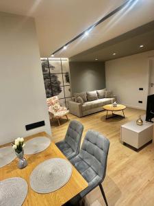 a living room with a couch and a table and chairs at Deluxe Aparthotel Central2 in Zalău