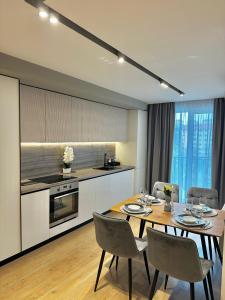 a kitchen and dining room with a table and chairs at Deluxe Aparthotel Central2 in Zalău +17 photos