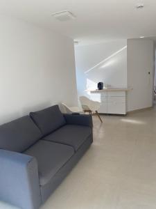a living room with a blue couch and a chair at La Fontana in Rauenberg