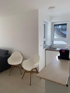 a living room with two white chairs and a table at La Fontana in Rauenberg