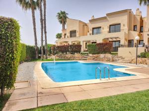 a house with a swimming pool and palm trees at RodaGolf Resort Nice Views in San Javier