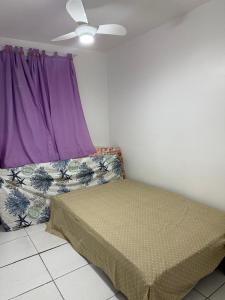 a bedroom with a bed and a purple window at Apartamento enseada in Guarujá