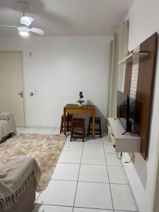a living room with a television and a table at Apartamento enseada in Guarujá +7 photos