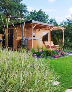a tiny house with a gazebo in a yard at Sjesta al mare, domki z sauną i balią z jacuzzi in Lubiatowo