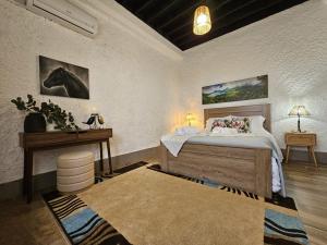 a bedroom with a bed and a table and a desk at Ocean View - Nordeste in Feteira Grande