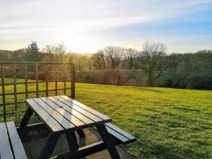 a wooden bench sitting in a field next to a fence at Keel Cottage in Whitby +5 photos