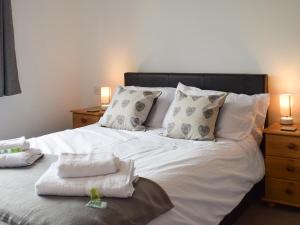 a white bed with pillows and towels on it at Keel Cottage in Whitby