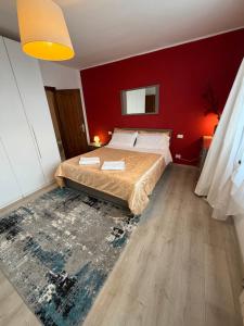 a bedroom with a bed and a red wall at Calle Boldu Venice in Venice