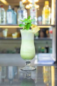 a glass vase with a plant in it on a table at The Cordis Hotel, Ikeja in Ikeja