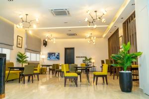 a dining room with tables and yellow chairs at The Cordis Hotel, Ikeja in Ikeja