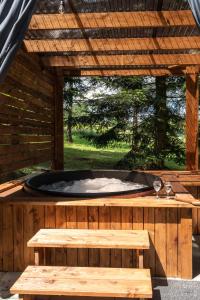 a hot tub in a wooden deck with a bench at Leśna Sielanka domek z jacuzzi w lesie pod Górą Szczebel RELAX I SPORT in Lubień