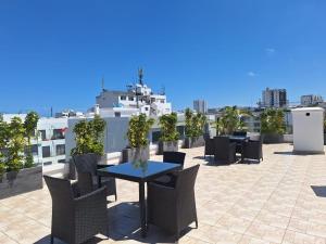 a patio with tables and chairs on a roof at Le Nid Doré in Maarif