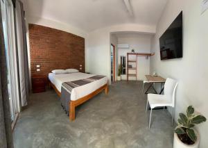 ein Schlafzimmer mit einem Bett und einer Ziegelwand in der Unterkunft Casa Sixta a 7min del aeropuerto internacional PMX y 2 cuadras terminal autob ADO in Puerto Escondido