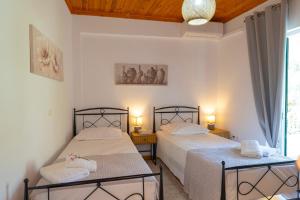 two beds in a room with two tables and two lamps at Casa Dimilia in Sívros