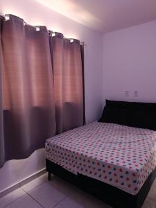 a bedroom with a bed with a polka dot sheet at Hostel de clecia in Extremóz