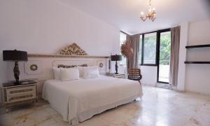 a bedroom with a large white bed and a chandelier at Villa Maraf - Adults Only Boutique Hotel in Cancún +86 photos