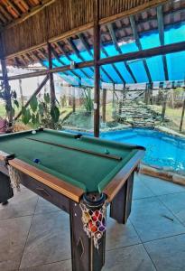 a pool table in front of a swimming pool at Pousada Mirante Serra Verde in Carrancas