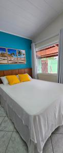 a large white bed in a room with a window at Flats KENAI in Abraão +115 photos